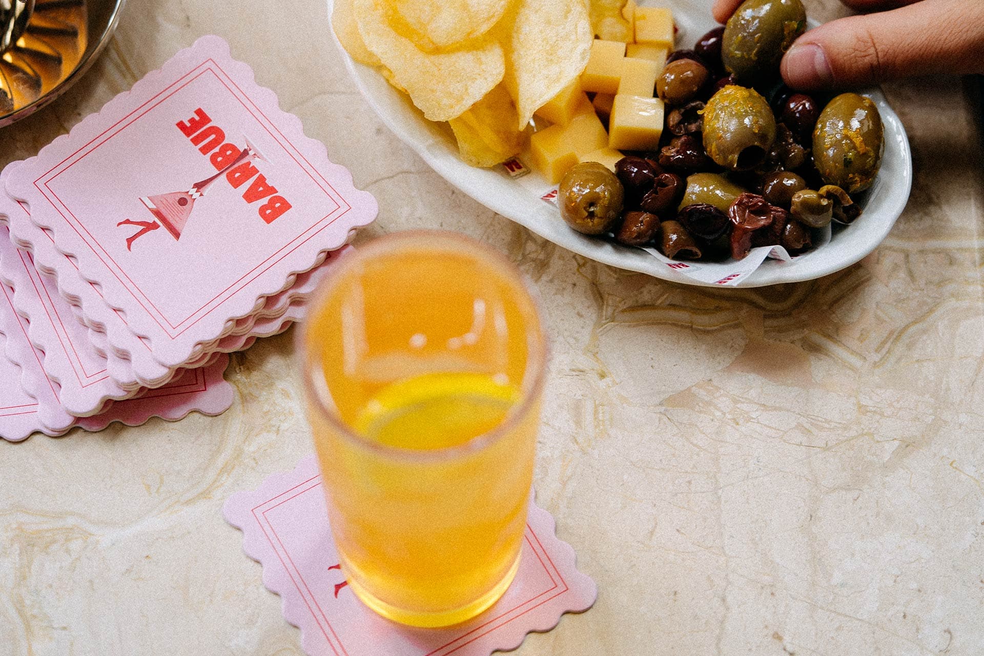 Crisps and olives served with beer on a marble bar